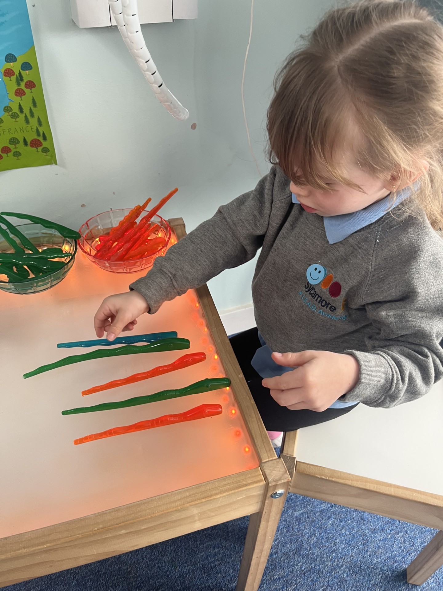 Sycamore Nursery child with plastic tubes on table